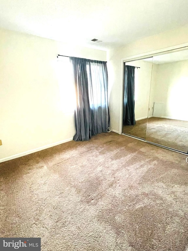 unfurnished bedroom featuring carpet and a closet