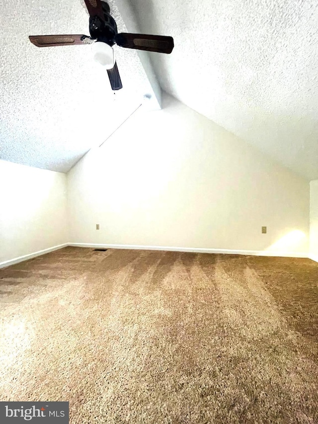 bonus room with carpet, ceiling fan, lofted ceiling, and a textured ceiling