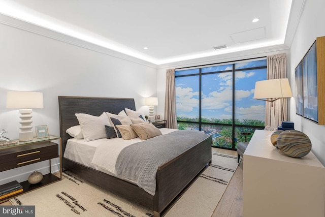 bedroom with crown molding, light hardwood / wood-style flooring, access to exterior, and floor to ceiling windows