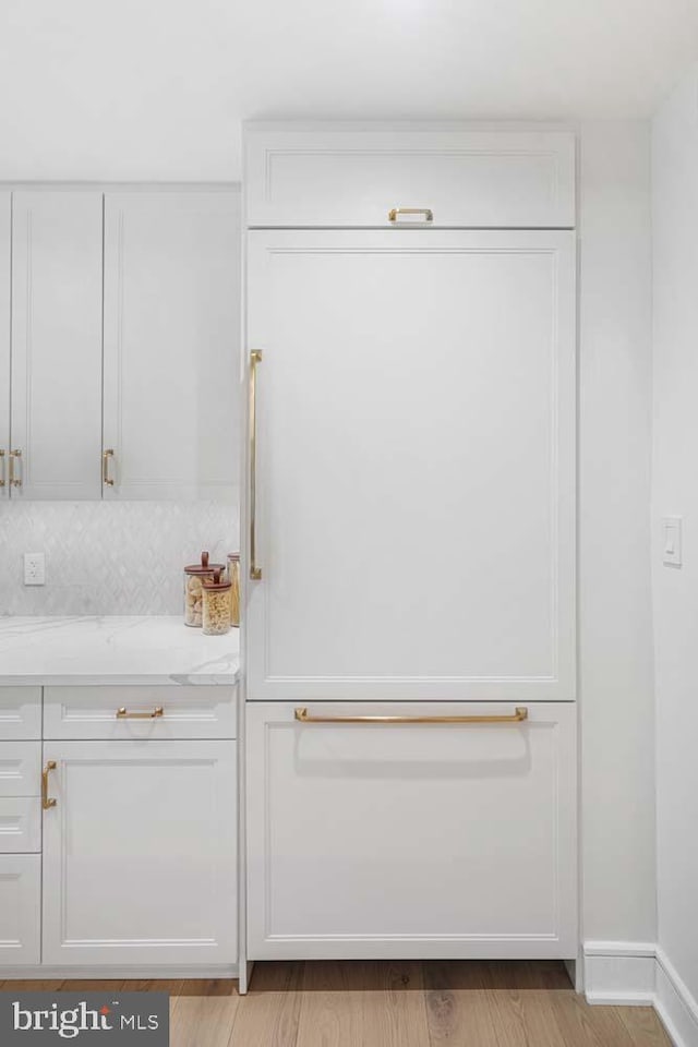 interior space featuring white cabinetry, light stone countertops, and light hardwood / wood-style flooring