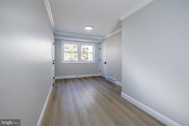 unfurnished room with crown molding and light hardwood / wood-style flooring