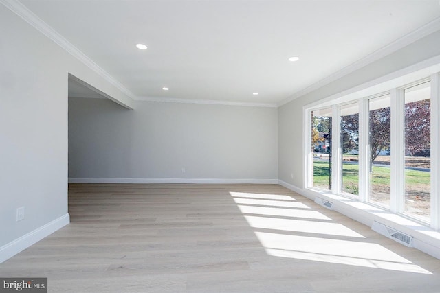 empty room featuring light hardwood / wood-style floors and crown molding