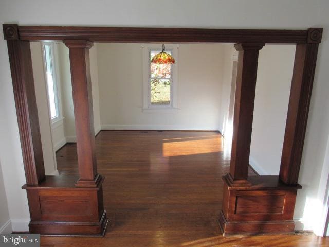 dining area with ornate columns and dark hardwood / wood-style floors