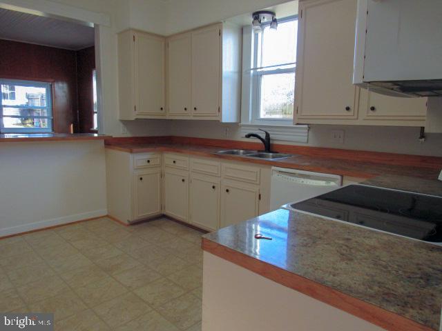 kitchen featuring white cabinetry, sink, and white dishwasher