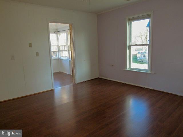 spare room with dark wood-type flooring and ceiling fan