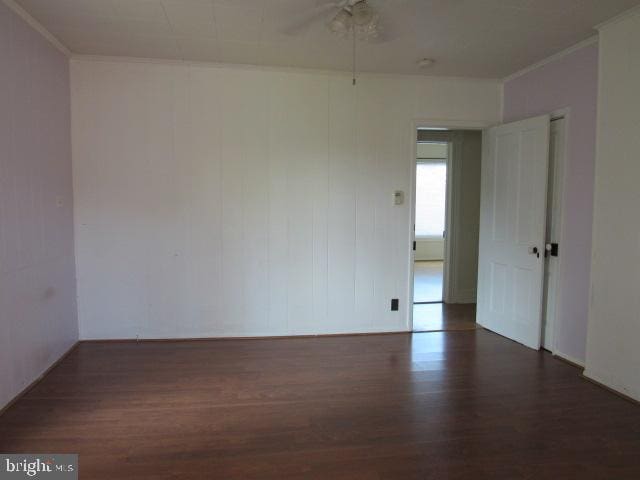 empty room with ceiling fan, dark hardwood / wood-style floors, and crown molding