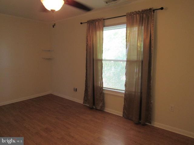 unfurnished room featuring dark hardwood / wood-style floors and ceiling fan