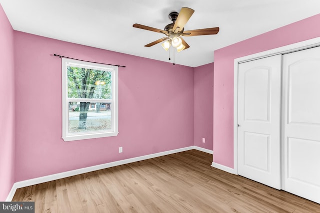 unfurnished bedroom featuring ceiling fan, light hardwood / wood-style floors, and a closet