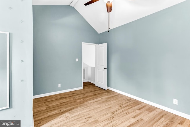 empty room featuring ceiling fan, light wood-type flooring, and high vaulted ceiling