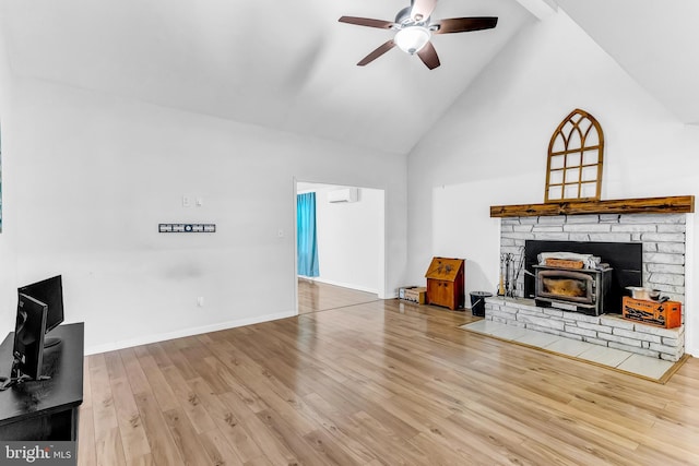 living room featuring a wood stove, ceiling fan, a wall mounted air conditioner, high vaulted ceiling, and hardwood / wood-style floors