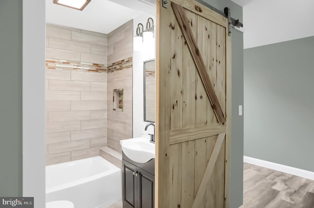 bathroom with vanity, wood-type flooring, and tiled shower / bath