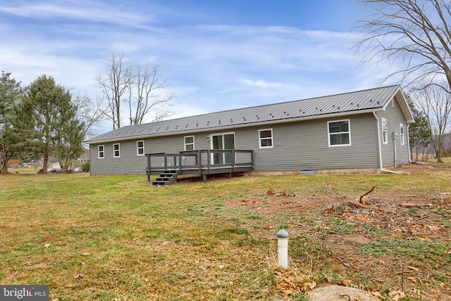 rear view of property featuring a lawn and a wooden deck