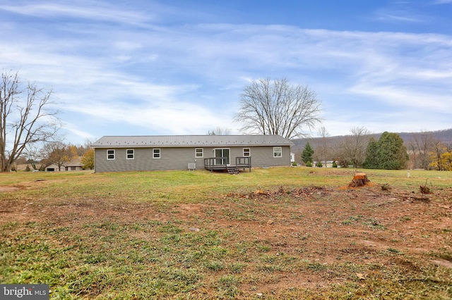 rear view of house with a lawn and a deck