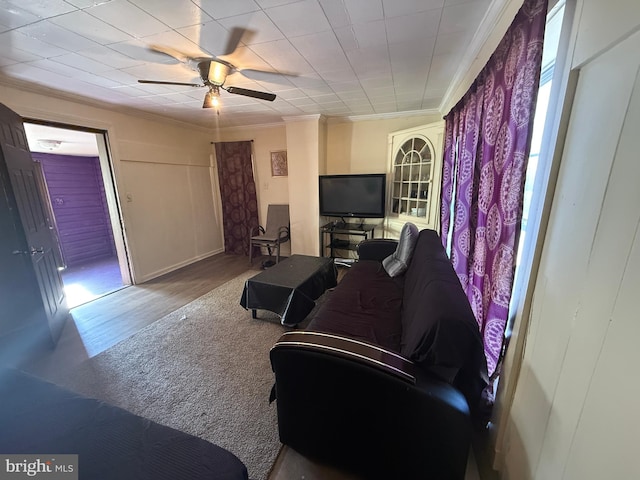 living room featuring ornamental molding, wood-type flooring, and ceiling fan