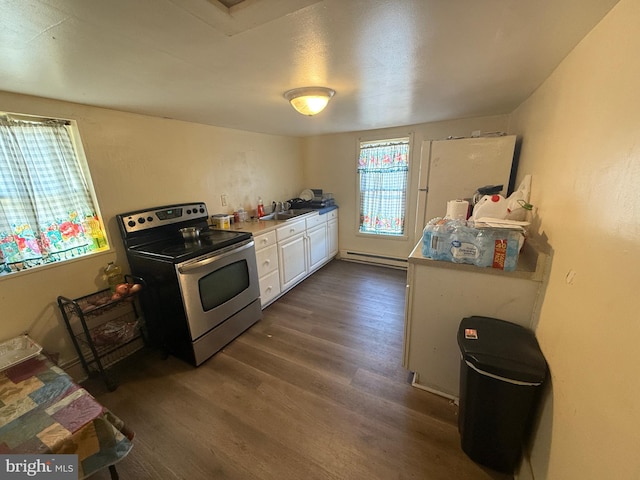 kitchen featuring stainless steel electric range, white cabinets, dark wood-type flooring, baseboard heating, and sink