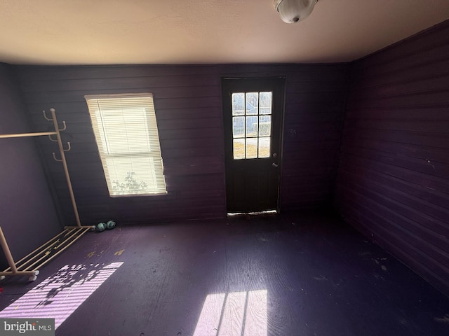 unfurnished room featuring wood walls