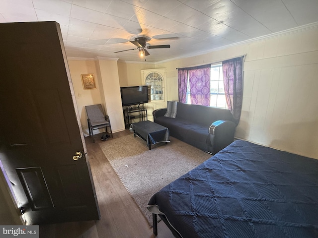 bedroom with crown molding, hardwood / wood-style flooring, and ceiling fan