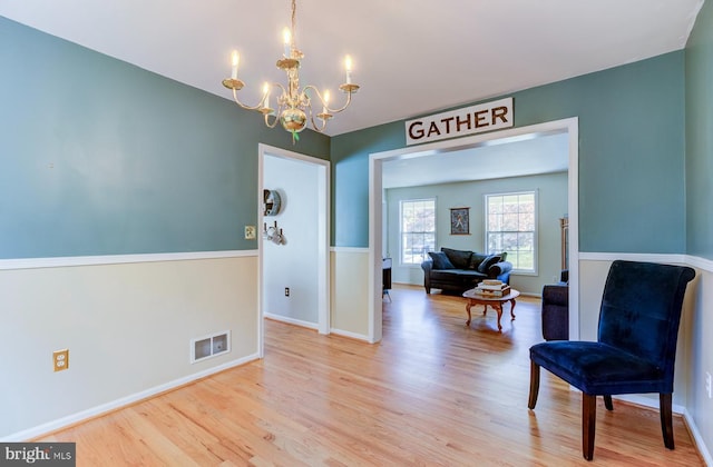 sitting room featuring a notable chandelier and light hardwood / wood-style flooring