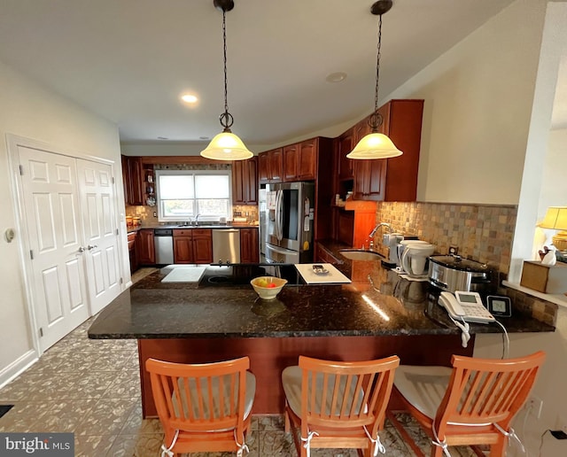 kitchen featuring decorative light fixtures, appliances with stainless steel finishes, sink, and kitchen peninsula