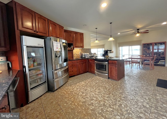 kitchen featuring stainless steel appliances, ceiling fan, decorative light fixtures, decorative backsplash, and kitchen peninsula