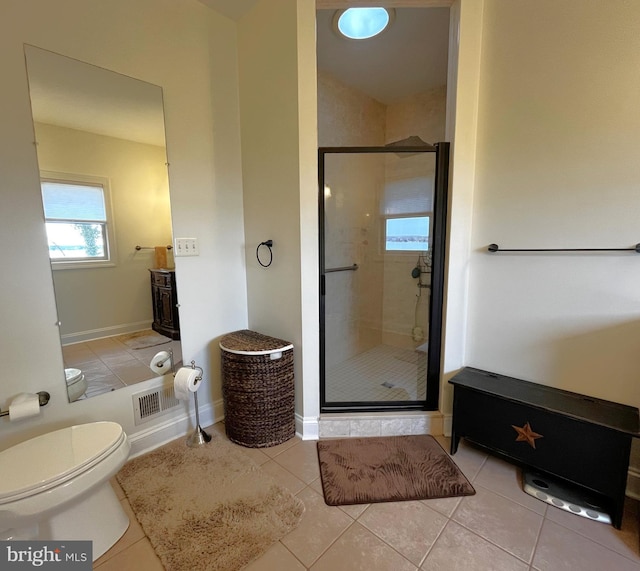 bathroom featuring tile patterned floors, a shower with shower door, and toilet