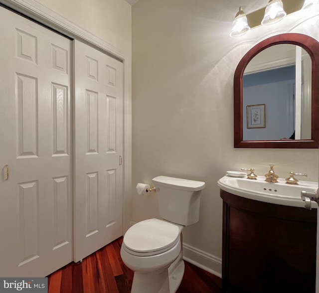 bathroom with toilet, wood-type flooring, and vanity