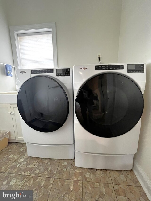 washroom featuring washer and clothes dryer and cabinets