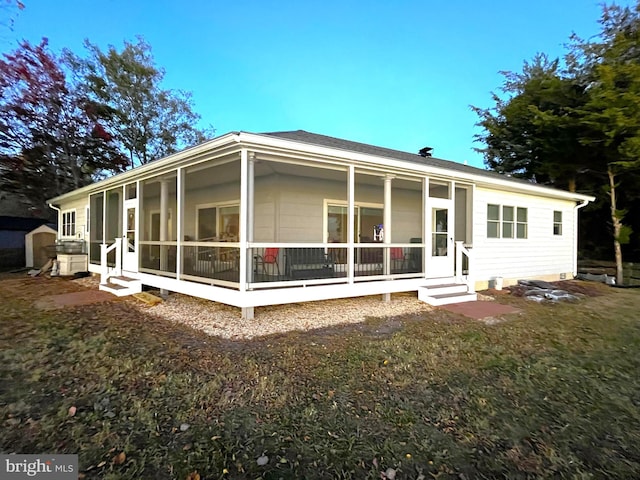 back of property featuring a lawn and a sunroom