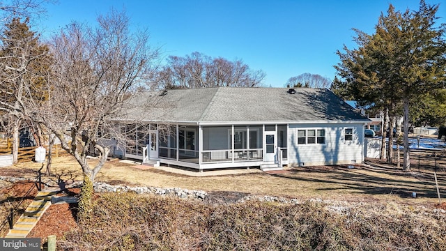 rear view of property featuring a yard and a sunroom