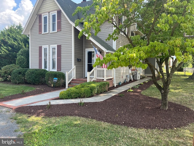 view of front of house with cooling unit and a front yard