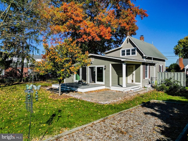 rear view of house featuring a yard and a patio