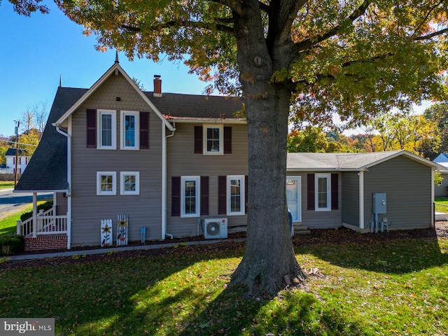 view of front of house featuring ac unit and a front lawn