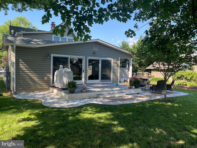 back of property featuring a patio area and a lawn