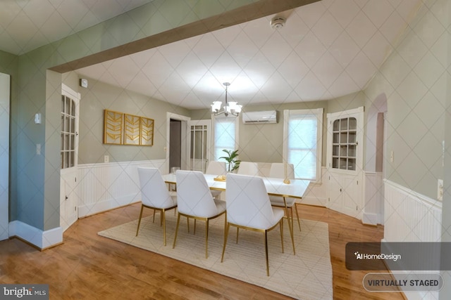 dining space featuring a notable chandelier, a wall mounted AC, and hardwood / wood-style floors