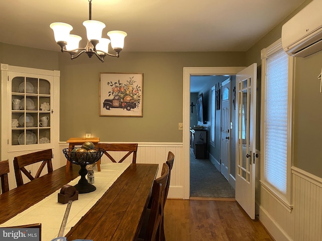 dining space with plenty of natural light, a chandelier, dark hardwood / wood-style flooring, and a wall mounted air conditioner