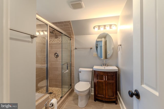 bathroom featuring toilet, a shower with shower door, vanity, and tile patterned flooring