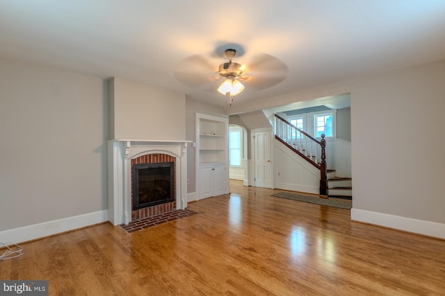 unfurnished living room featuring light hardwood / wood-style flooring, a fireplace, and ceiling fan