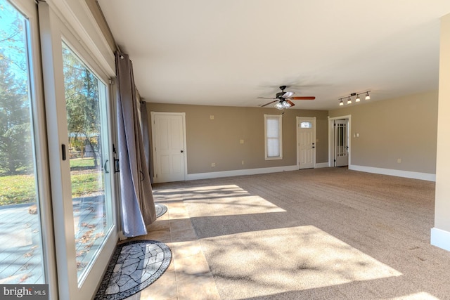 interior space featuring light colored carpet, track lighting, and ceiling fan