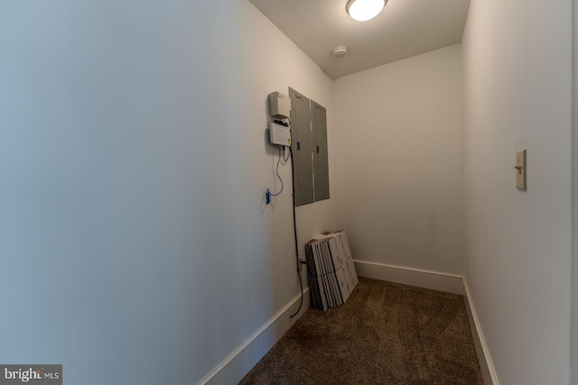 hall with electric panel and dark colored carpet