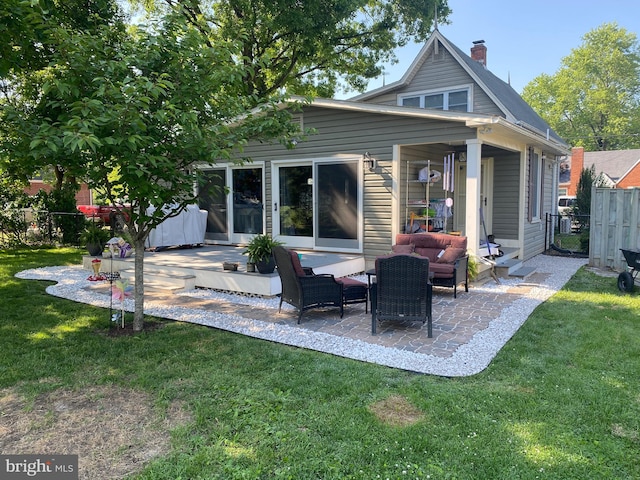 rear view of property featuring an outdoor hangout area, a yard, and a patio area