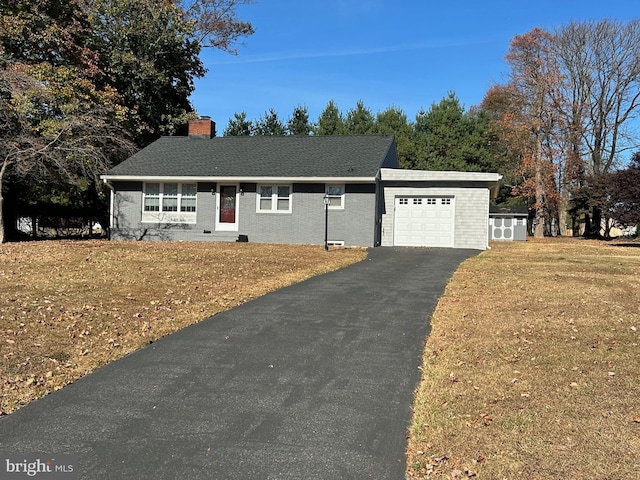 ranch-style house featuring a garage and a front lawn