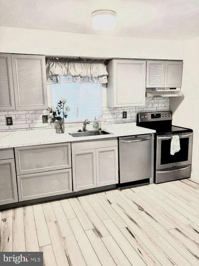 kitchen with gray cabinets, sink, appliances with stainless steel finishes, and light hardwood / wood-style floors