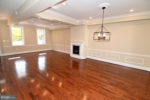 unfurnished living room featuring dark hardwood / wood-style flooring, a notable chandelier, and ornamental molding