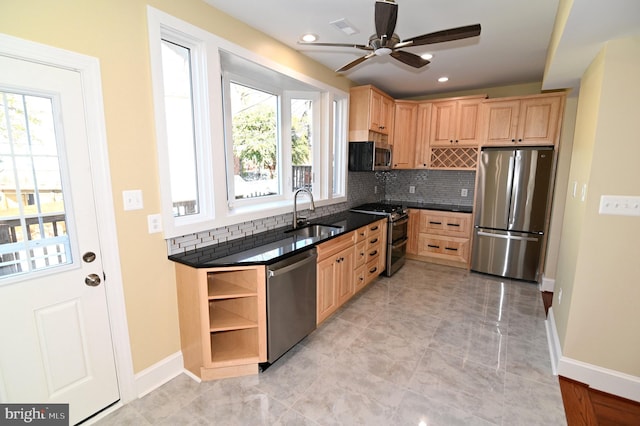 kitchen featuring a healthy amount of sunlight, sink, backsplash, and appliances with stainless steel finishes