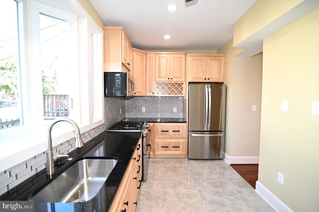 kitchen featuring stainless steel appliances, sink, tasteful backsplash, light tile patterned flooring, and light brown cabinets