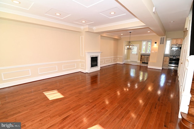 unfurnished living room with a fireplace, an inviting chandelier, dark hardwood / wood-style floors, and crown molding