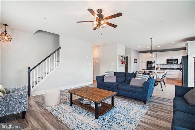 living room with ceiling fan and hardwood / wood-style flooring