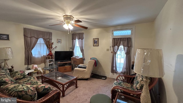 carpeted living room with ceiling fan and baseboard heating