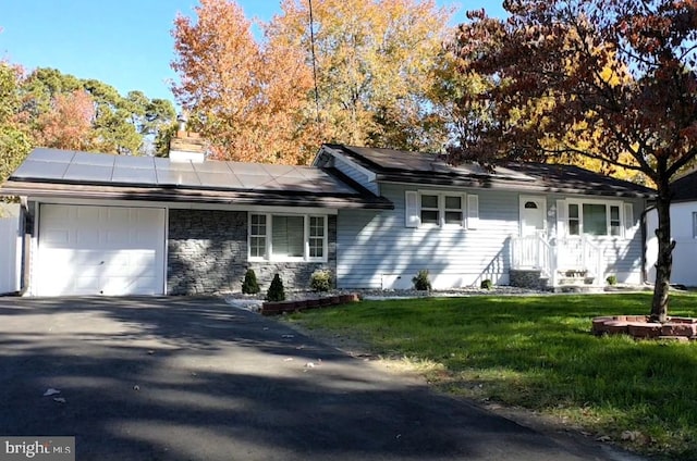 ranch-style house featuring a front lawn and a garage