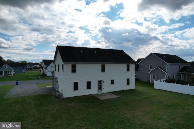 back of property featuring a lawn and central AC unit